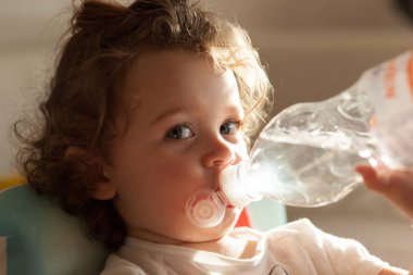 Tatlı su plastik şişeden içme küçük bebek kız.