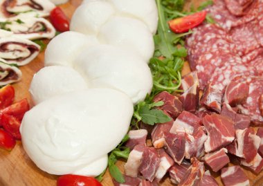 Mozzarella shaped braid on cutting board with salami and cheese. clipart