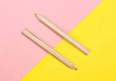 Sarı ve pembe arka plan üzerinde renkli kalemler. Düz yatıyordu fotoğraf