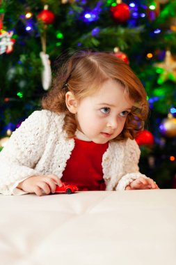 Güzel küçük alt küçük kırmızı oyuncak araba ile çalış.