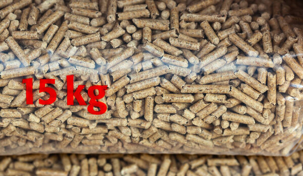 Куча пластиковых пакетов по пятнадцать килограммов, наполненных древесными гранулами
.