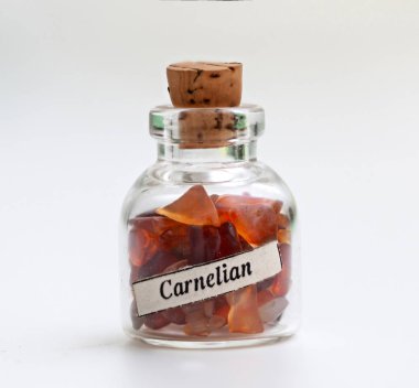 Beyaz arka plan üzerinde carnelian taşlarla küçük şişe.