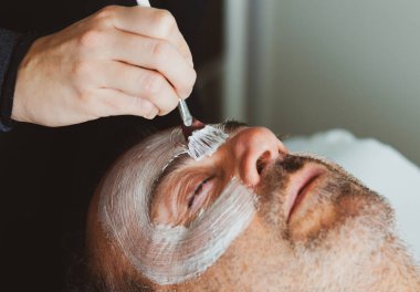 Orta yaşlı adam bir yüz maskesi ile güzellik salonu.