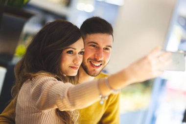Bardaki güzel genç çift cep telefonu ile bir selfie alarak.