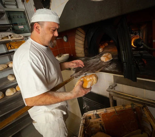 Produção de pão assado com forno a lenha em uma padaria . — Fotografia de Stock