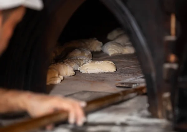Produkcja chleba upieczony z piec opalany drewnem, w piekarni. — Zdjęcie stockowe
