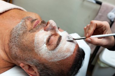 Orta yaşlı adam bir yüz maskesi bulunan bir spa.