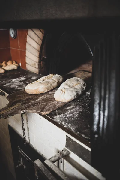 Produzione di pane al forno con forno a legna in panetteria . — Foto Stock