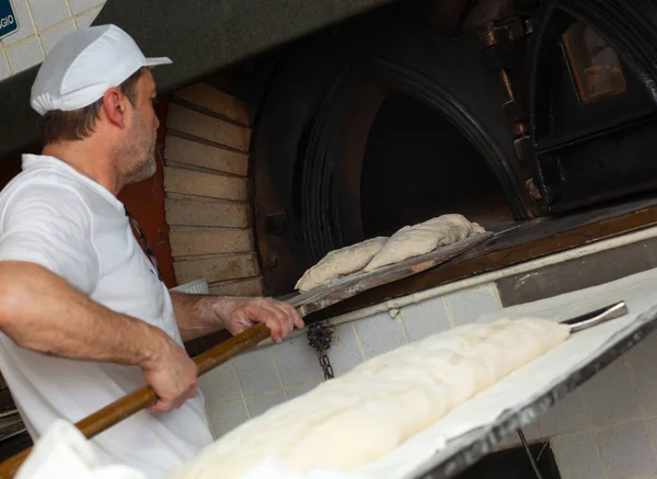 Production of baked bread with a wood oven in a bakery. — Stock Photo, Image