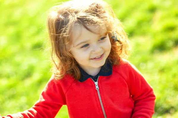 緑の芝生によそ見かわいい幼児. — ストック写真