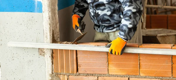 Metselaar installeren van baksteen metselwerk op interieur wand. — Stockfoto