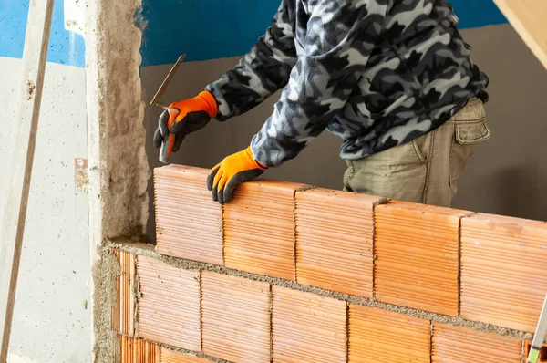 Bricklayer installing brick masonry on interior wall. — Stock Photo, Image