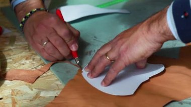 Shoemaker veya ayakkabı tasarımcısı deri kesme için lwith kağıt modelleri ile çalışma.