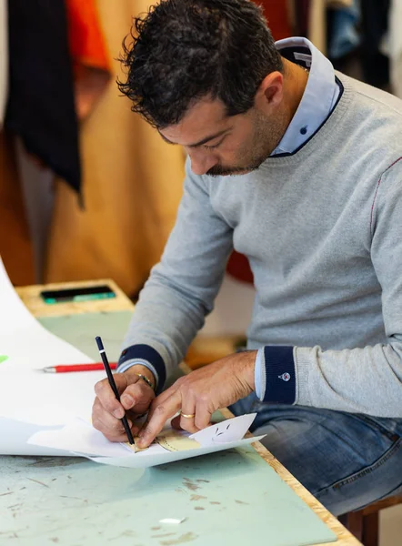 Schoen ontwerper werkt met papier modellen voor het snijden van leder. — Stockfoto