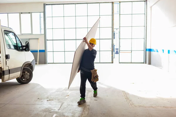 Εργαζόμενος χτίζει ένα τοίχωμα γυψοσανίδας. — Φωτογραφία Αρχείου