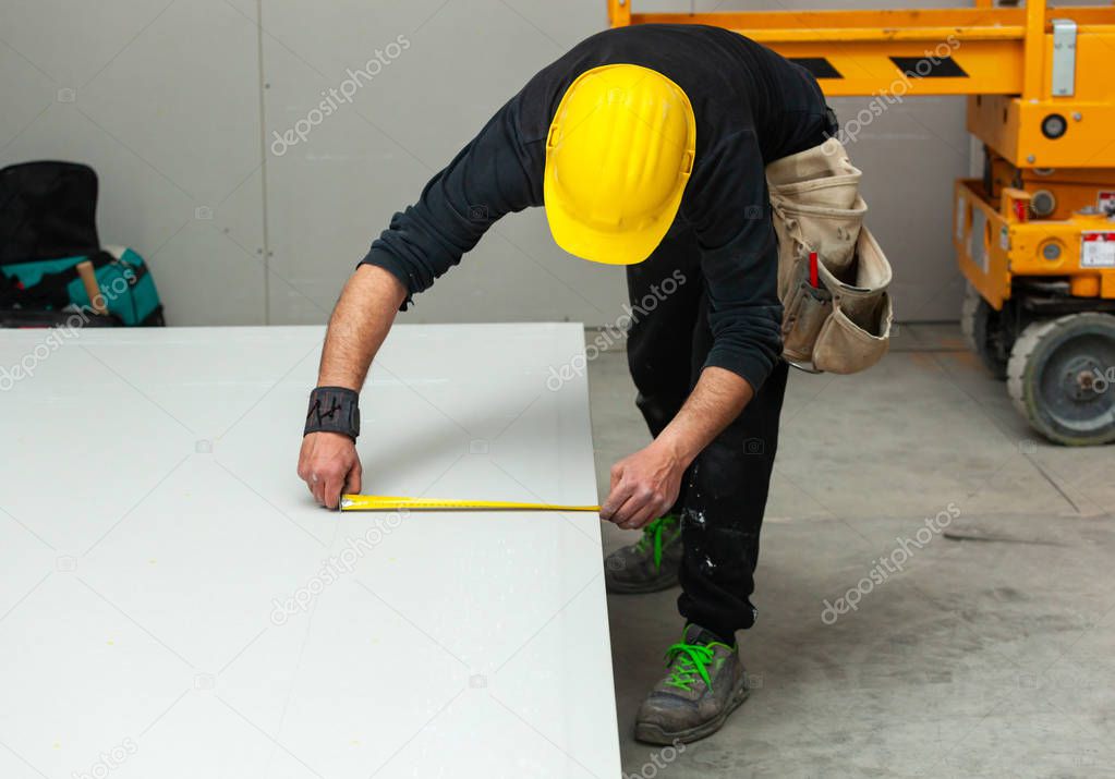 Worker builds a plasterboard wall.