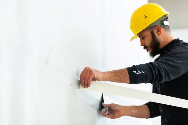 Arbeiter verputzt Wand aus Gipskartonplatten. — Stockfoto