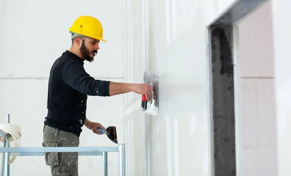 Arbeiter verputzt Wand aus Gipskartonplatten. — Stockfoto