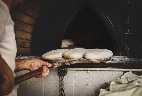 Herstellung von gebackenem Brot mit einem Holzofen in einer Bäckerei. — Stockfoto