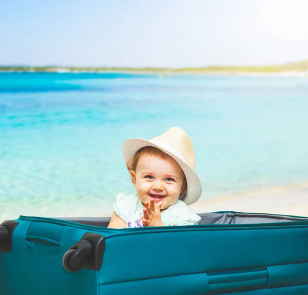 Девочка сидит в чемодане на пляже . — стоковое фото