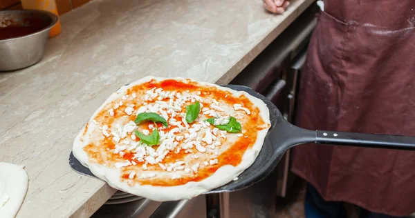 Raw margherita pizza on baking shovel. — Stock Photo, Image