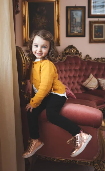 Menina criança em uma sala de estar com decoração barroca . — Fotografia de Stock