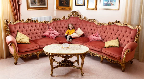 Niña en una sala de estar con decoración barroca . — Foto de Stock