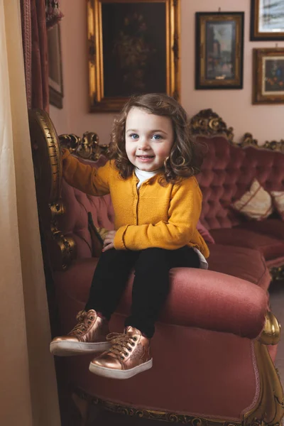 Menina criança em uma sala de estar com decoração barroca . — Fotografia de Stock