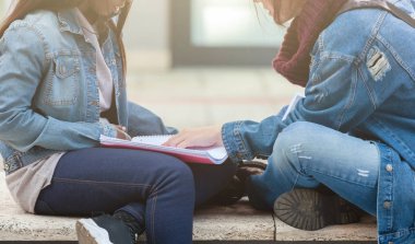 İki genç kadın bir bankta çalışma.