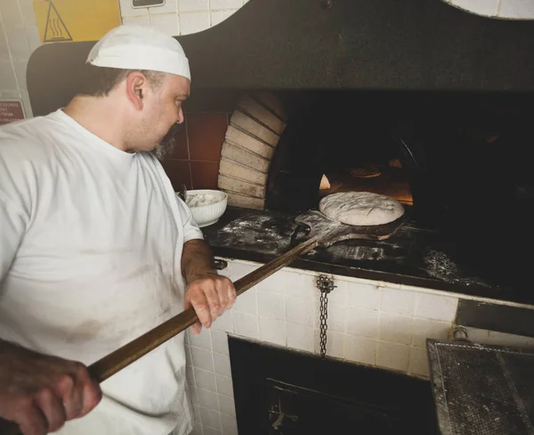 Production de pain cuit au four à bois dans une boulangerie . — Photo