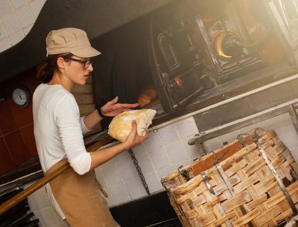 Productie van gebakken brood met een houtoven in een bakkerij. — Stockfoto