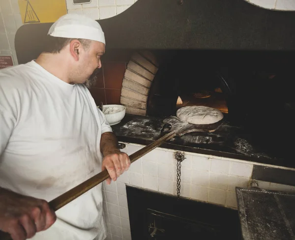Production of baked bread with a wood oven in a bakery. Stock Image