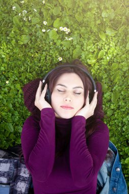 Müzik dinleyen genç kadının üst görünümü.