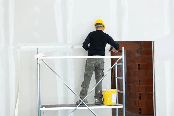 労働者は石膏ボードの壁を石膏. — ストック写真