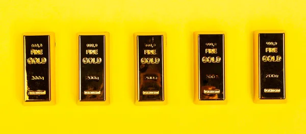 Bares de ouro bullion no fundo amarelo . — Fotografia de Stock