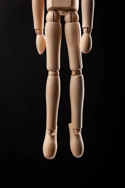 Figurine en bois pendue avec une corde Isolé sur fond noir . — Photo