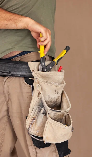 Trabajador utiliza cinturón de herramientas, momento auténtico y real . — Foto de Stock