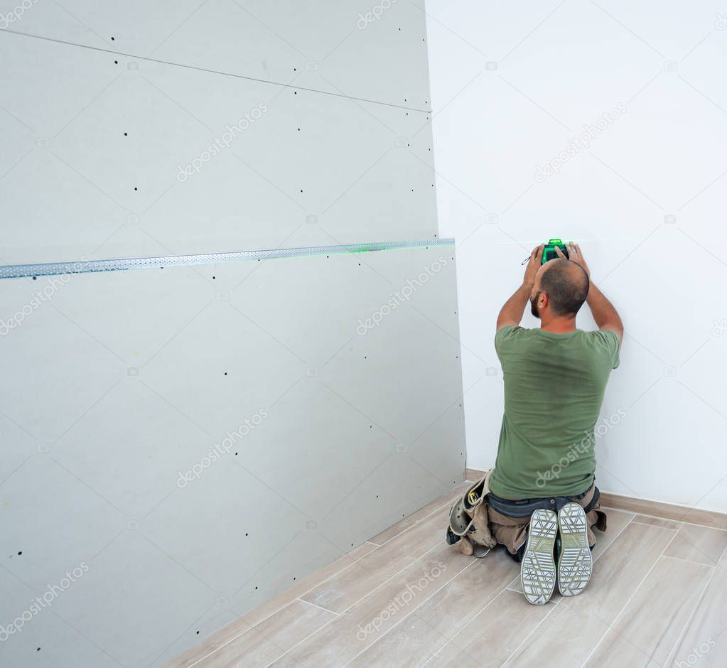 Worker building plasterboard wall.