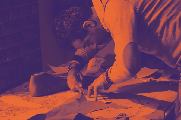 Skodesigner som arbetar med läder. Bitonal effekt — Stockfoto