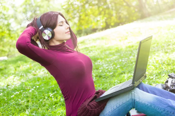 Nette junge Frau hört Musik mit Kopfhörern. — Stockfoto