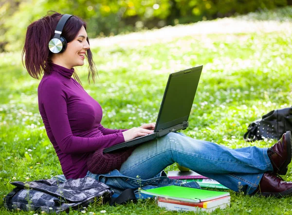 Nette junge Frau hört Musik mit Kopfhörern. — Stockfoto