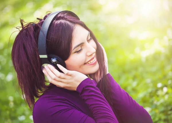 Nette junge Frau hört Musik mit Kopfhörern. — Stockfoto