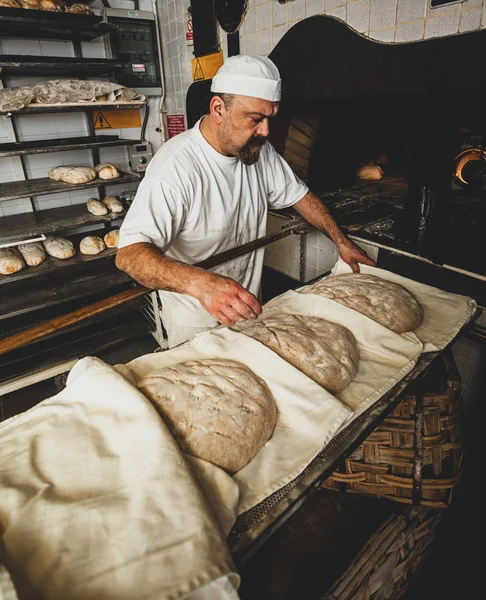 Herstellung von gebackenem Brot mit einem Holzofen in einer Bäckerei. — Stockfoto