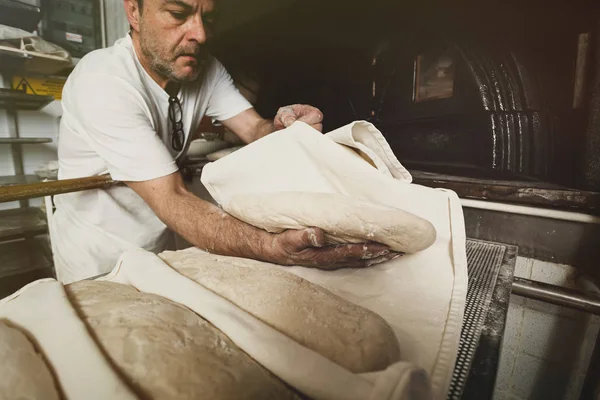 Production of baked bread with a wood oven in a bakery. — Stock Photo, Image