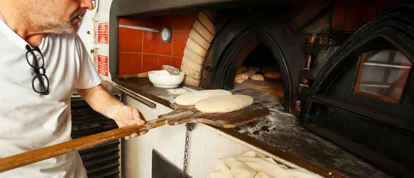 Egy pékség fatüzelésű kemencében sült kenyér előállítása. — Stock Fotó