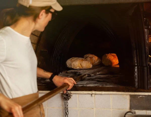 Produktion av bröd med en vedeldad ugn i ett bageri. — Stockfoto