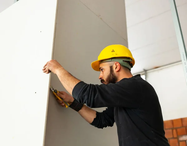 Werknemer bouwt een muur gipsplaat. — Stockfoto