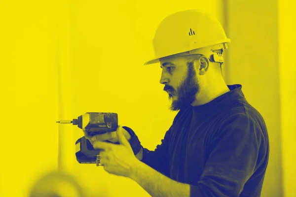 Werknemer bouwt een gipsplaat wand. Tweekleurig effect. — Stockfoto