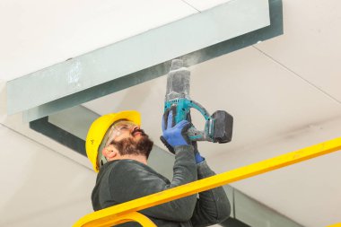 İşçi bir alçıpan duvar oluşturur.