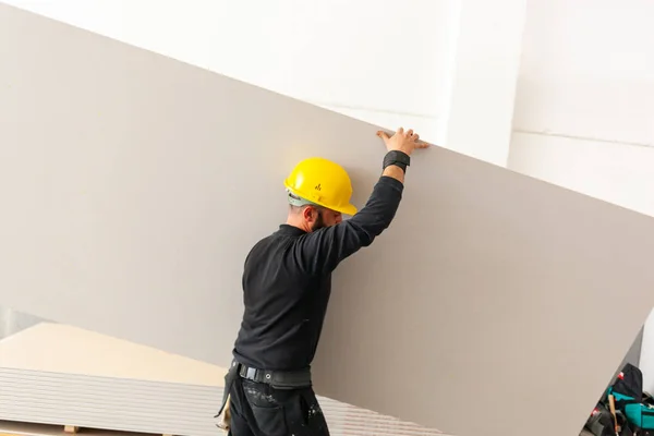 Werknemer bouwt een muur gipsplaat. — Stockfoto